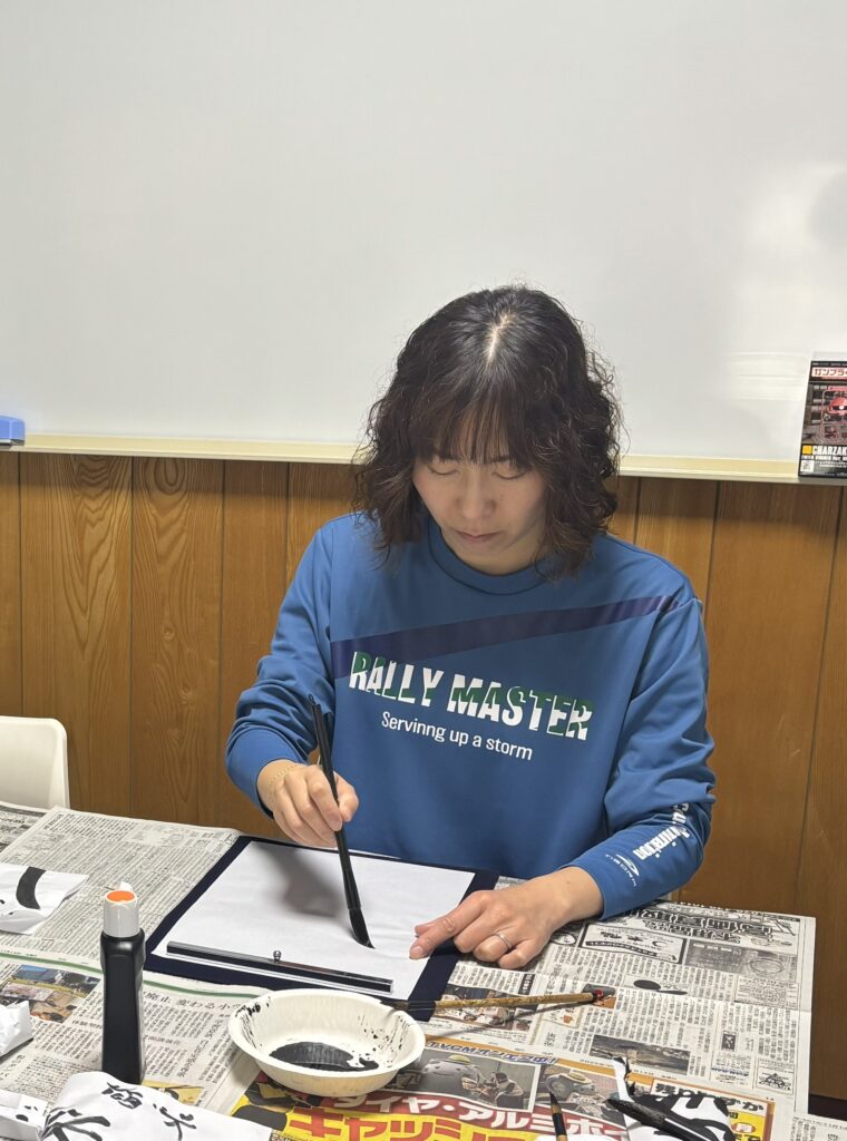 新春書き初め大会でのスタッフの取り組みショットです。